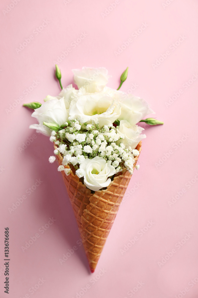 Fototapeta Waffle cone with composition of beautiful flowers on pink background