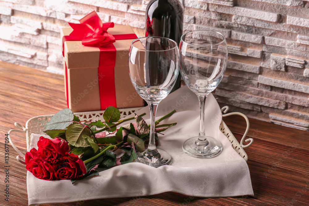 St. Valentines Day concept. Wine, roses and gift box on wooden table St. Valentines Day concept. Wine, roses and gift box on wooden table