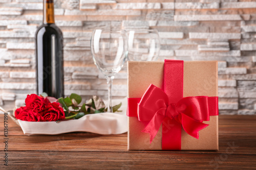 St. Valentines Day concept. Wine, roses and gift box on wooden table