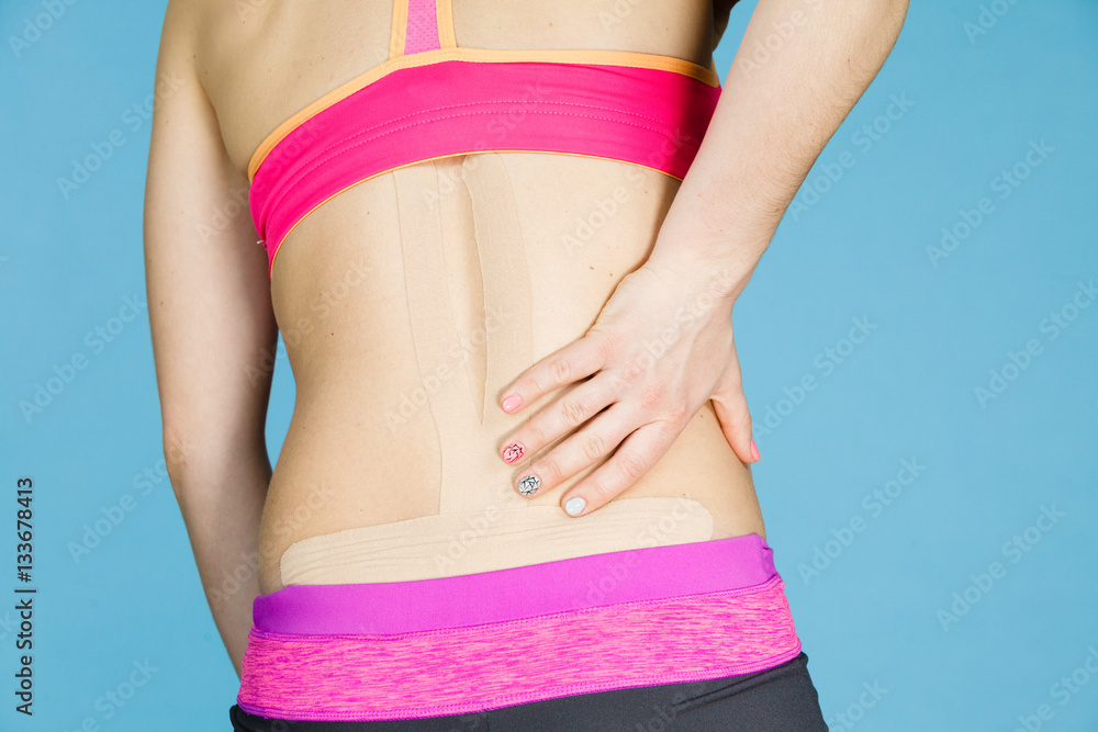 Woman with medical kinesio taping on back Woman with medical kinesio taping on back