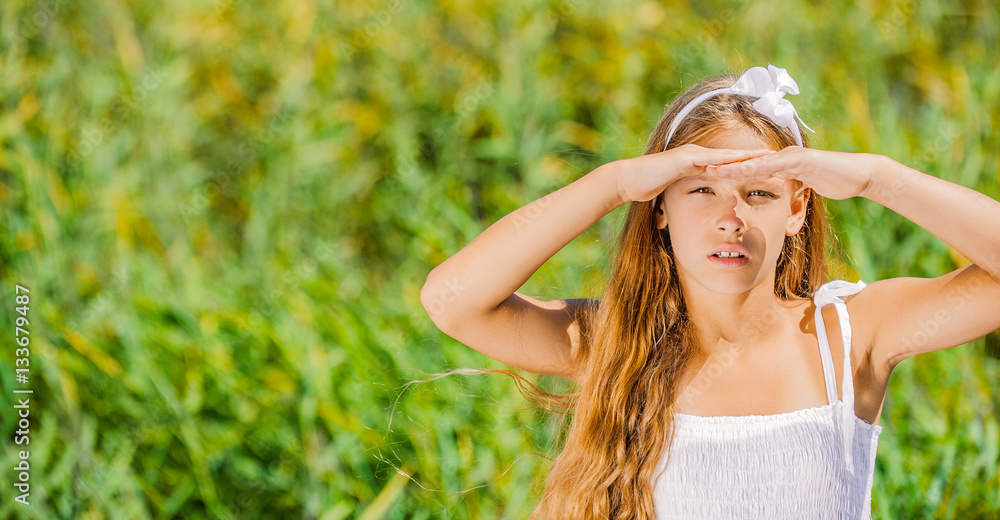 young girl of hand covers her eyes from sun StockFoto Adobe Stock