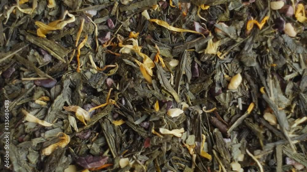 Green tea flavored with chocolate and almond pieces, close up. Loopable rotation. In front of the camera rotates plate with green tea.