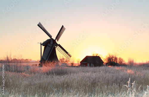 sunrise over frosted meadow and windmill