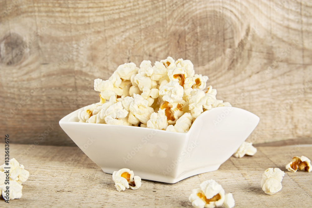 Bowl full of popcorn on wooden background Bowl full of popcorn on wooden background