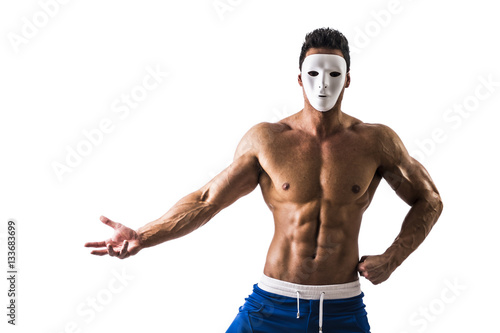 Shirtless muscle man with creepy, scary mask on tilted head, isolated on white background