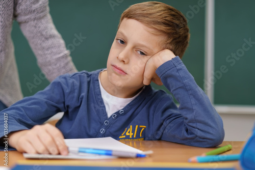 Foto junge in der schule stützt genervt den kopf auf