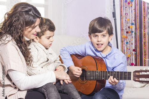Portrait of happy family playing guitar