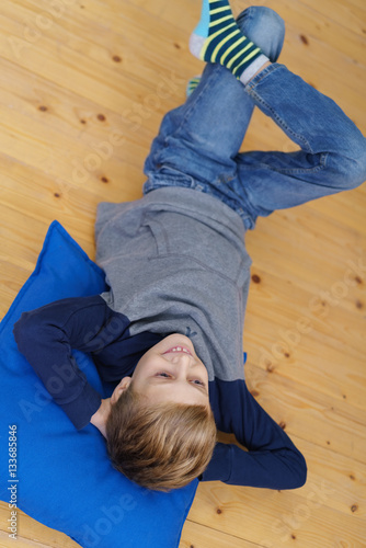 kleiner junge liegt entspannt auf dem fußboden © contrastwerkstatt