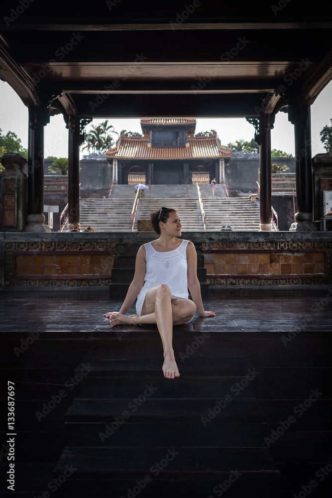 Young woman sitting at old traditional temple in Vietnam. Beautiful girl tourist happy lifestyle. Traveling in Asia. Young woman sitting at old traditional temple in Vietnam. Beautiful girl tourist happy lifestyle. Traveling in Asia.