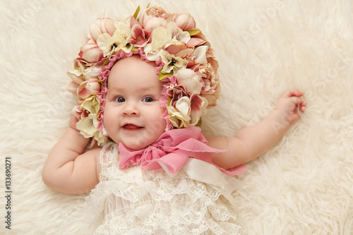 Маленькая девочка в цветочной шапке улыбается