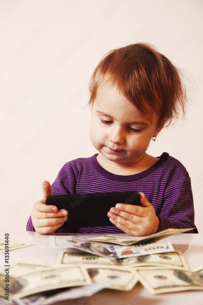 Happy successful business baby girl holding a smartphone in fron Happy successful business baby girl holding a smartphone in fron