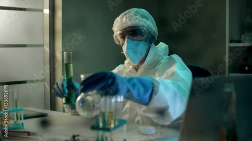 Crazy mad scientist in respirator develop and test himself a new tasteless drink or beverage. He shakes his head. Unsuccessful experiment. Joke in chemical lab