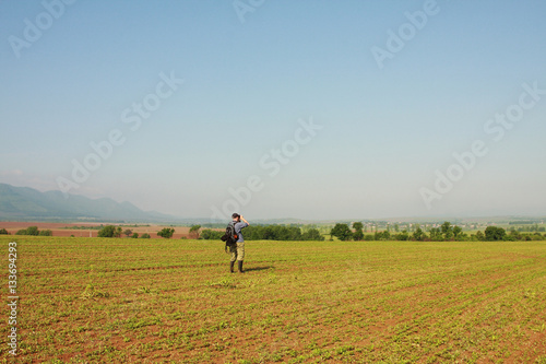 A man is watching birds on field background, sunny and blue sky