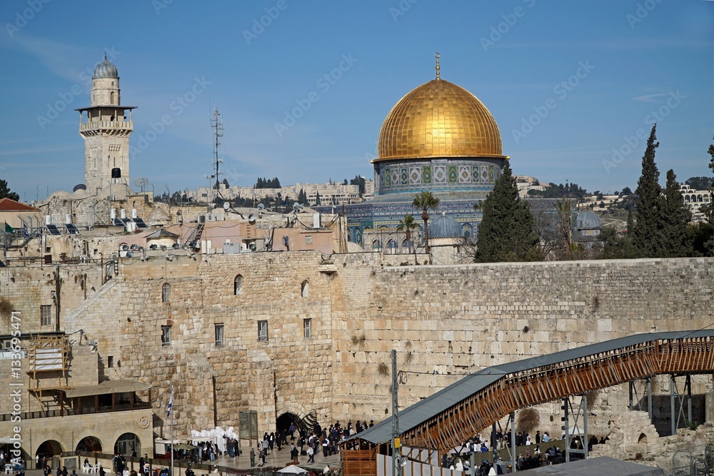 JERUSALEM - JANUARY 2017:  The Dome of the Rock sits above the Western Wall of the detroyed Jewish temple, with a wooden ramp for non-Muslim visitors, as seen in Jerusalem circa 2017
