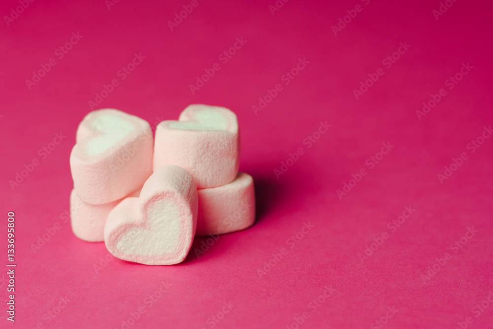 Marshmallows in heart shapes for Valentines day over pink paper Marshmallows in heart shapes for Valentines day over pink paper