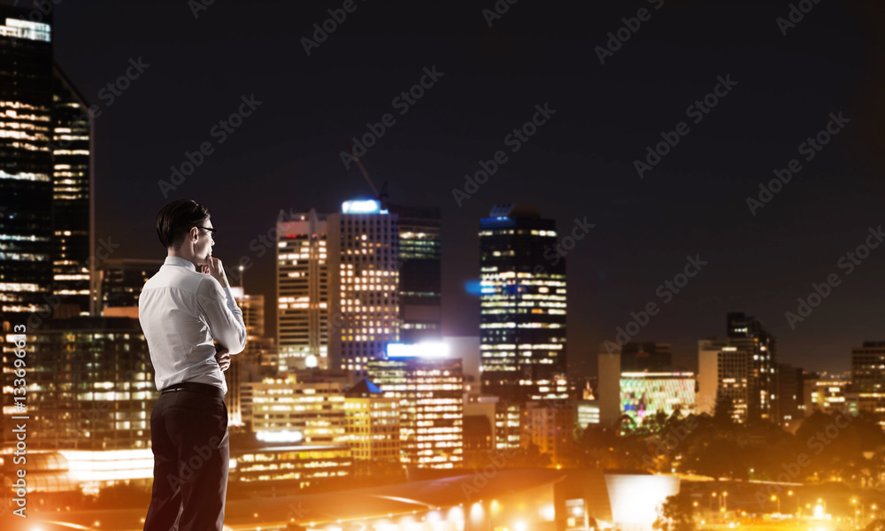 Businessman viewing night glowing city Businessman viewing night glowing city
