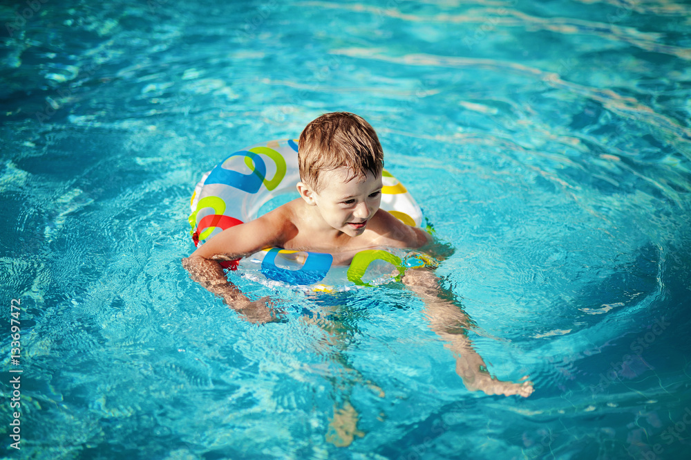 Child in a swimming pool having his first swim lessons