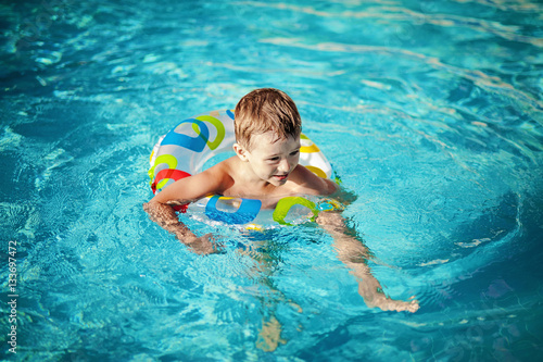 Child in a swimming pool having his first swim lessons