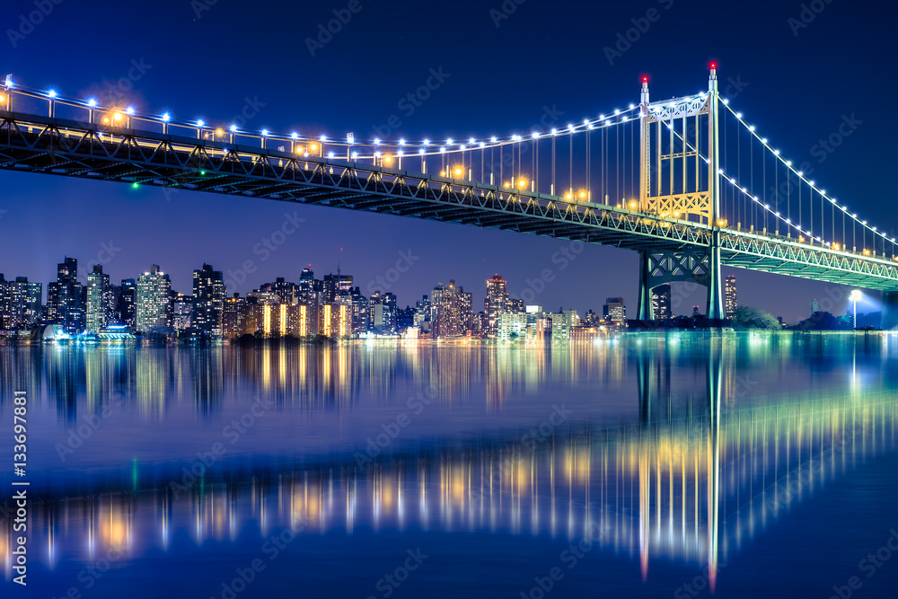 Beautiful night view with lights of Robert F. Kennedy RFK bridge formerly known as the Triborough bridge from Astoria Queens across the East River toward New York City upper Manhattan skyline