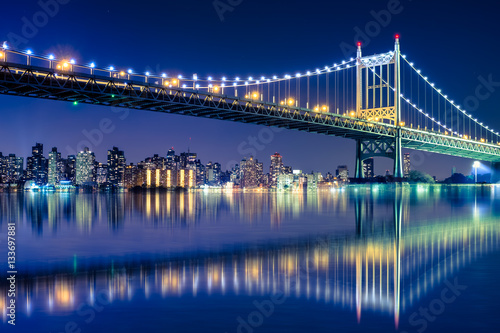 Beautiful night view with lights of Robert F. Kennedy RFK bridge formerly known as the Triborough bridge from Astoria Queens across the East River toward New York City upper Manhattan skyline