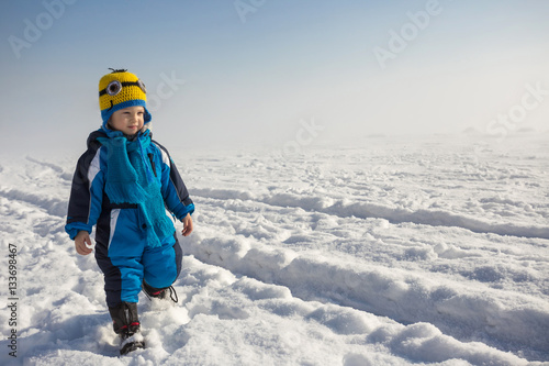 young boy playing on snow outdoors