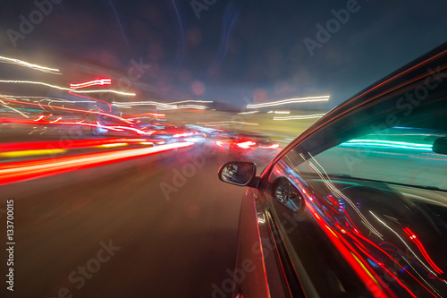 View from Side of Car moving in a night city, Blured road with lights with car on high speed. Concept rapid rhythm of a modern city. © pozdeevvs