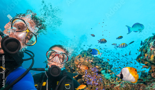 Scuba divers looking at camera underwater