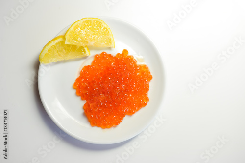 Eggs of red caviar on white surface background. Top view flat lay image