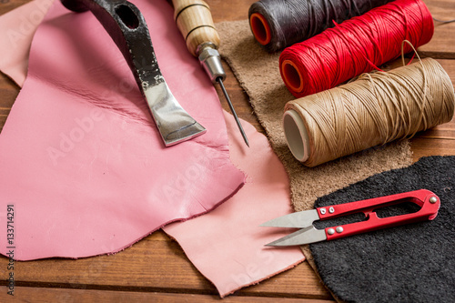 leather craft instruments on wooden background close up