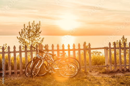 Bicycles leaning on a fence by the beach