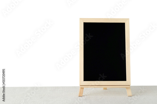 Blank chalkboard standing on sack tablecloth isolated on white
