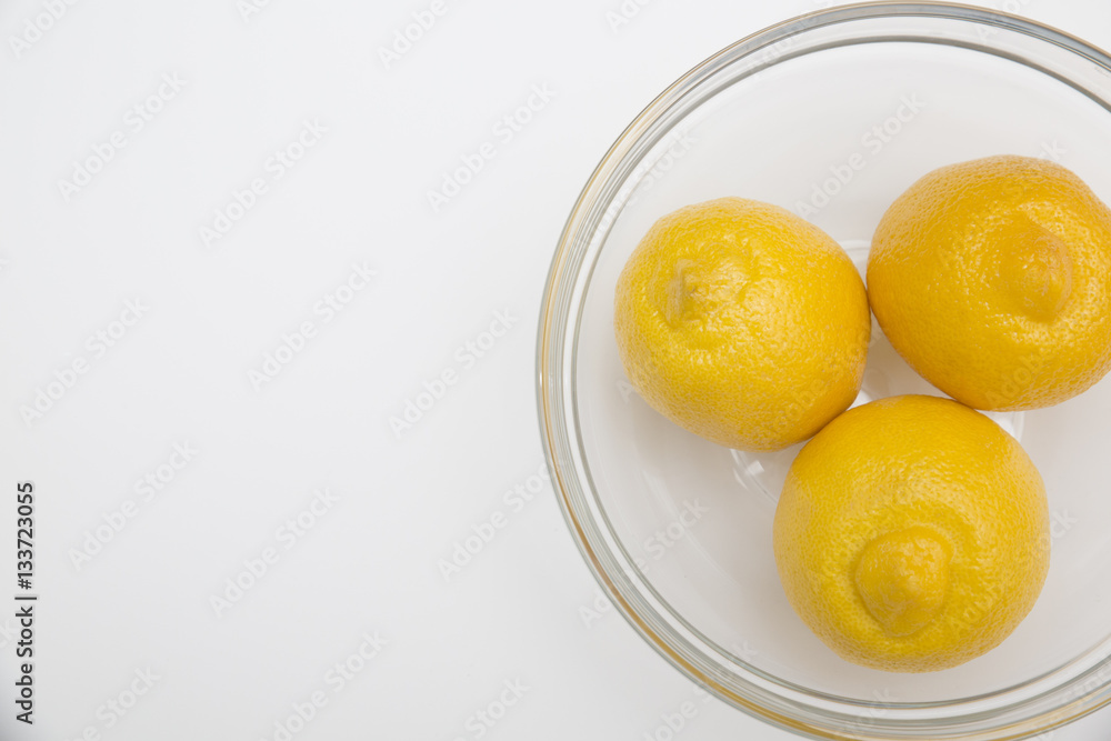 Fresh lemons in a glass bowl Fresh lemons in a glass bowl