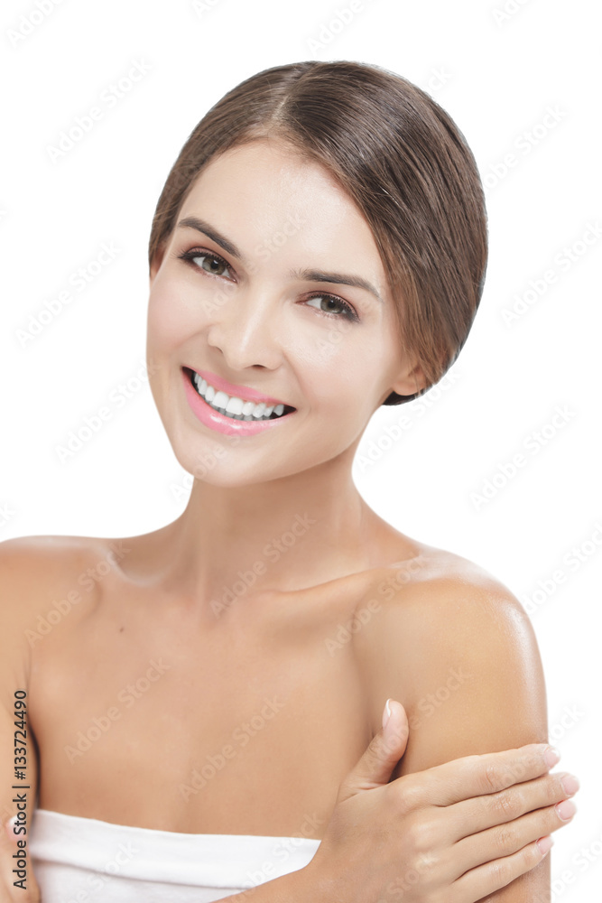 beautiful woman applying body lotion to her arms while smiling beautiful woman applying body lotion to her arms while smiling
