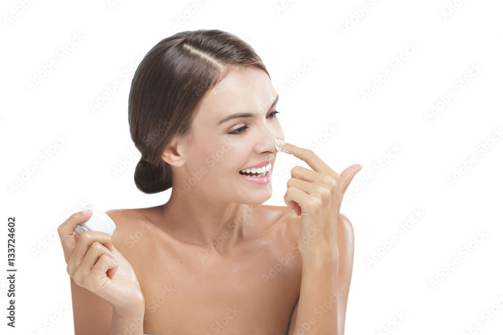 beautiful young woman smiling while take some facial cream and a beautiful young woman smiling while take some facial cream and a