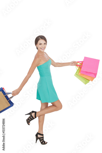 happy shopping woman swinging shopping bag while walking