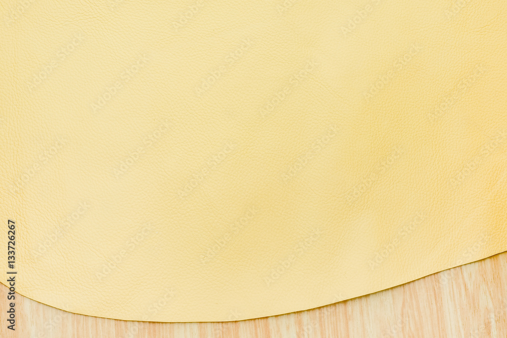 Close up at bright yellow color leather texture on wood table Close up at bright yellow color leather texture on wood table