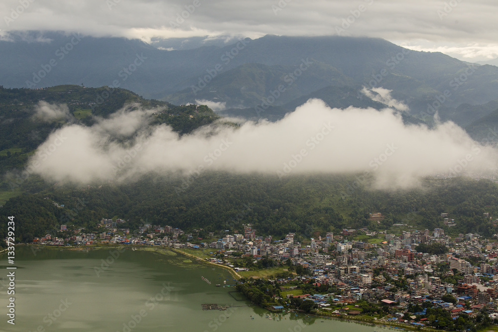 Lake Phewa and houses Pokhara, Nepal, with the Himalayan mountains in the background