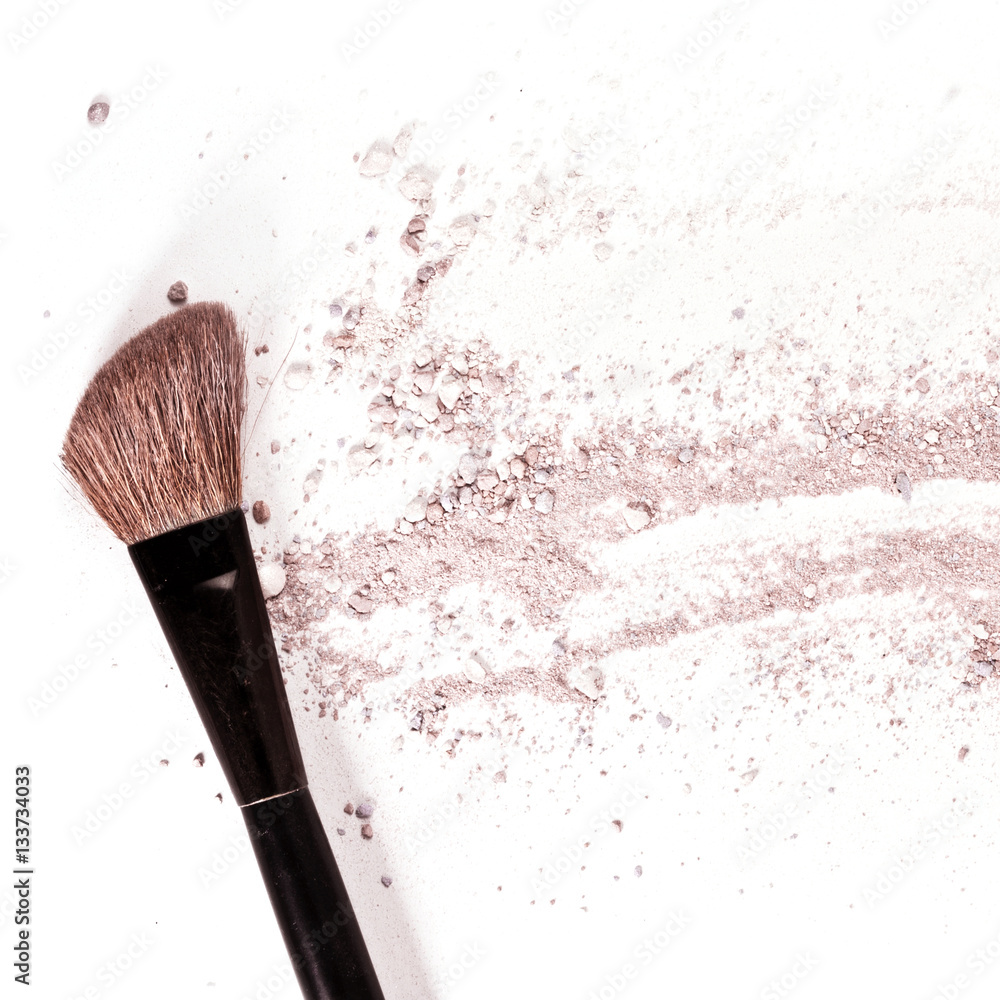 Makeup brush on white background, with traces of powder