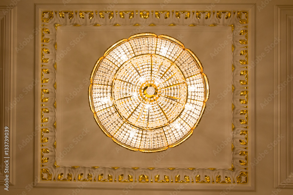 Crystal luxury chandelier in golden ballroom