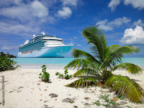 Cruise ship anchored close to a tropical beach in the Caribbean Sea.