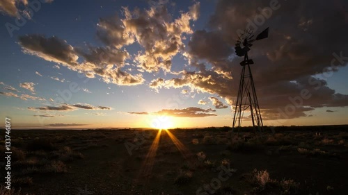 Timelapse of windmill with clouds and sunset in american desert photo