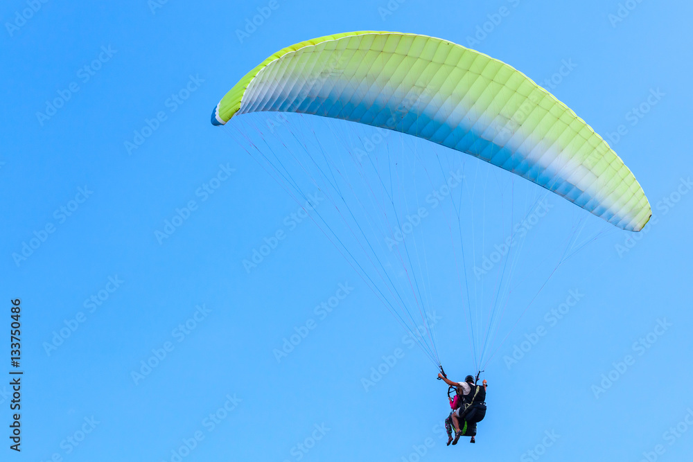 Paragliding in blue sky, instructor and beginner Paragliding in blue sky, instructor and beginner