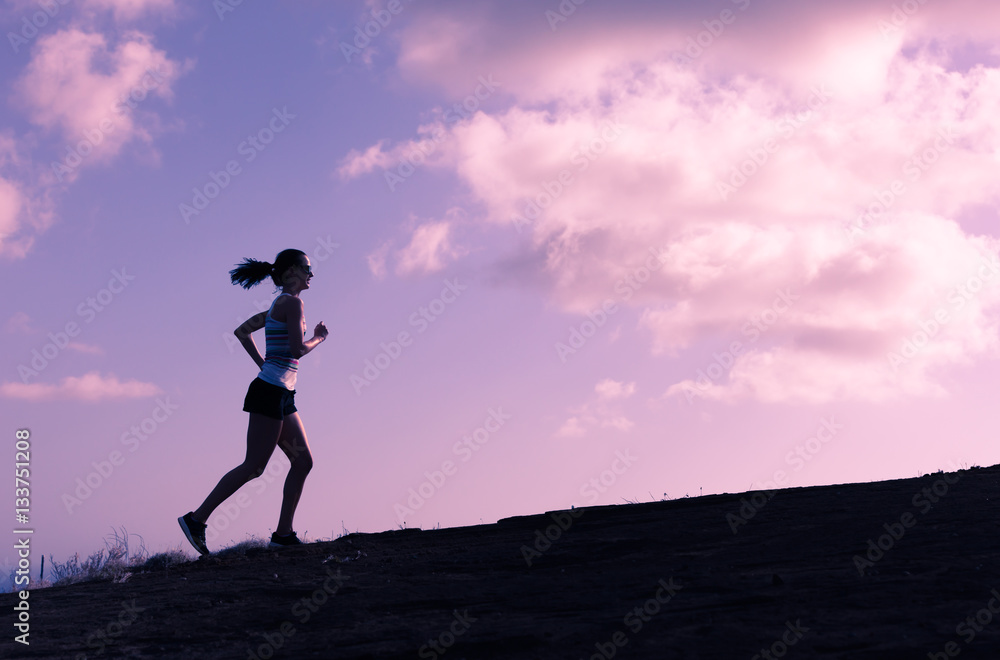 Silhouette of female runner running up a hill. Silhouette of female runner running up a hill.