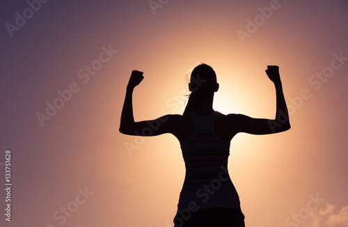 Fotografie Woman power! Strong confident woman flexing her muscles.
