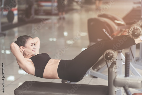 Delighted woman doing sit ups while training