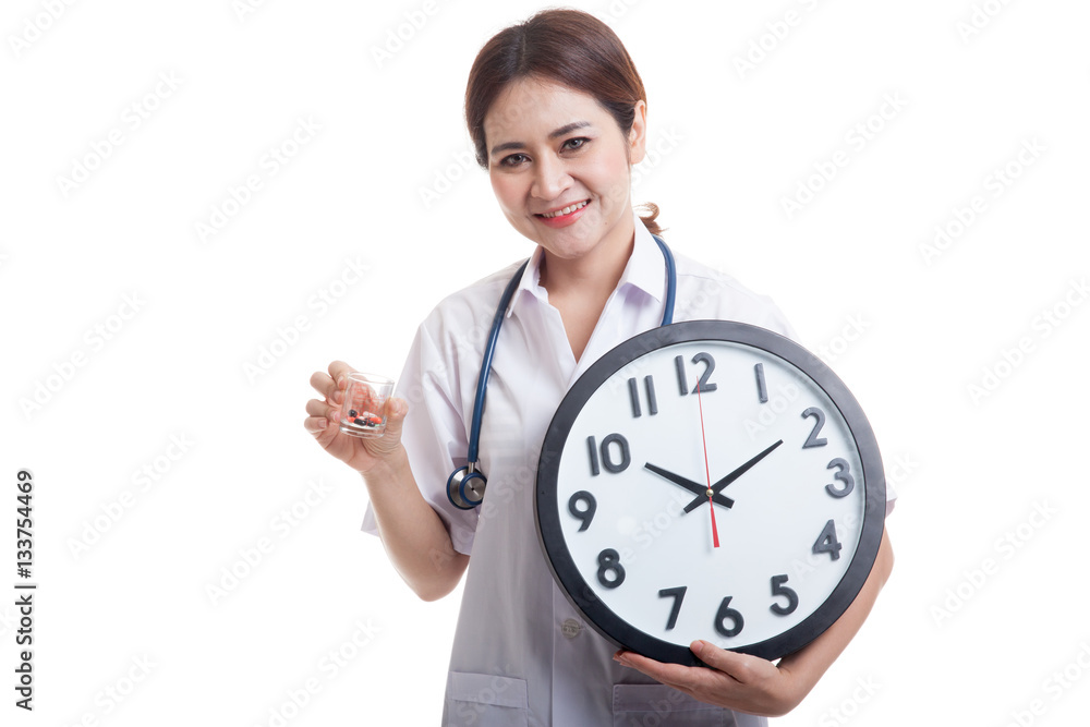 Young Asian female doctor smile with a clock and pills. Young Asian female doctor smile with a clock and pills.