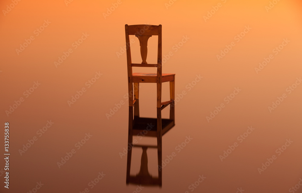 Wooden chair on the surface of a pond