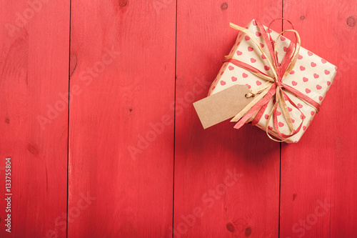 Gift box on red wooden table