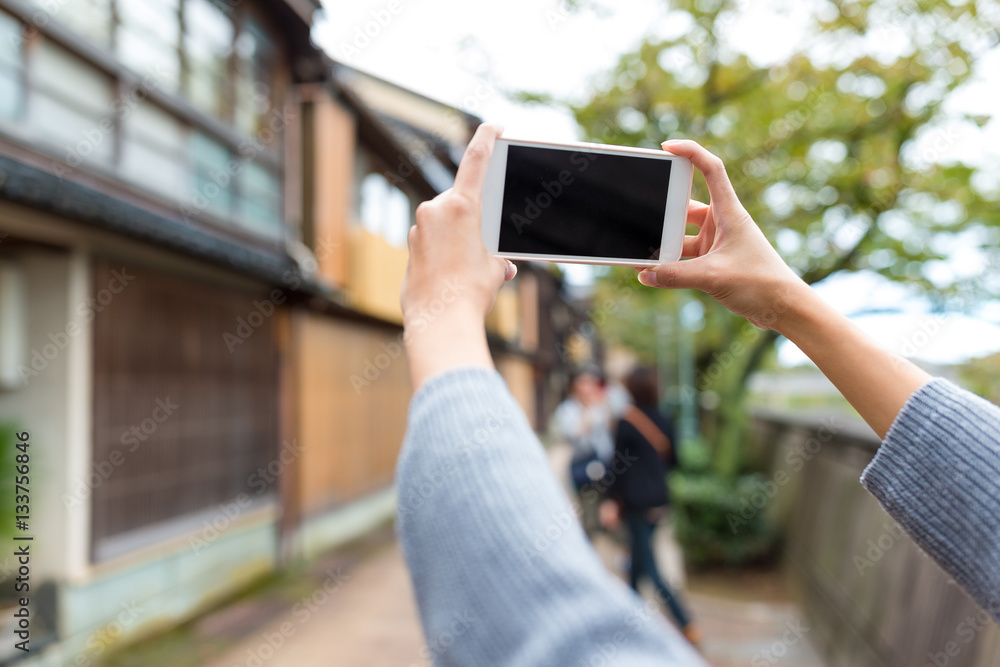 Taking photo by cellphone in old town of Japan