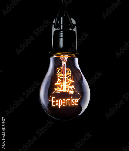 Hanging lightbulb with glowing Expertise concept. photo